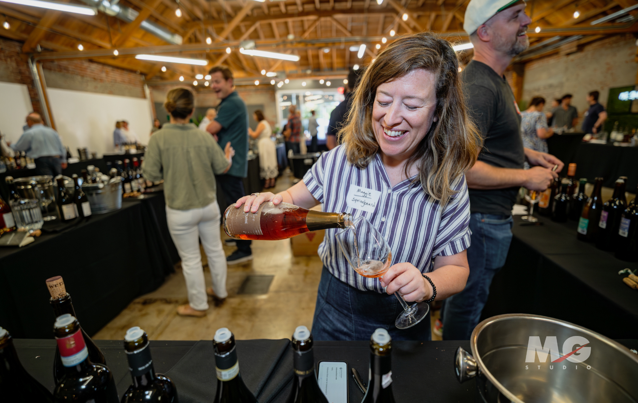 Tasting Event at MG Studio - pouring wine for guest into glass